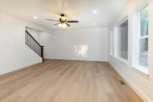 Empty room with light wood-type flooring, recessed lighting, stairway, and a ceiling fan