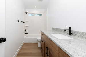 Bathroom featuring vanity, shower / washtub combination, light wood-style flooring, and recessed lighting