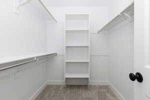 Walk in closet featuring light colored carpet