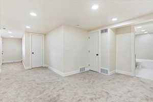 Basement with recessed lighting and light colored carpet