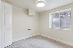 Carpeted spare room featuring baseboards