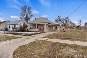 View of front of house featuring concrete driveway, a chimney, an attached carport, and a porch
