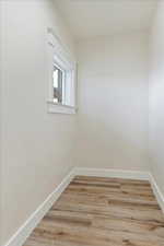 Spare room featuring light wood-style flooring and baseboards