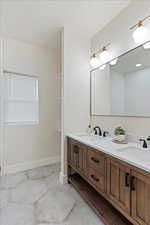 Bathroom with double vanity and baseboards