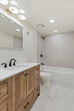 Full bathroom featuring vanity, bathtub / shower combination, recessed lighting, and light marble finish flooring