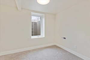 Empty room with baseboards and light colored carpet