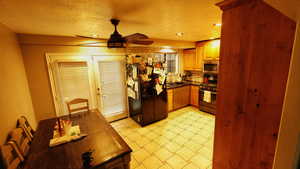 Kitchen featuring dark countertops, appliances with stainless steel finishes, a textured ceiling, tasteful backsplash, and recessed lighting