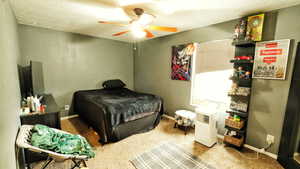 Bedroom featuring carpet, ceiling fan, and a textured ceiling