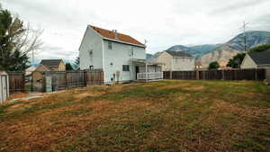 Rear view of house with a fenced backyard and a mountain view