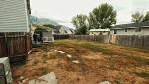Fenced backyard featuring a deck with mountain view and a residential view