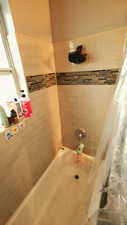 Full bathroom with shower / bathtub combination with curtain