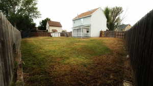 Fenced backyard featuring a shed