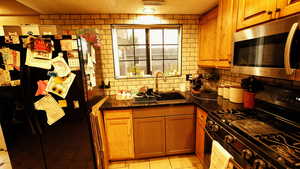 Kitchen featuring stainless steel appliances, brown cabinetry, backsplash, and light tile patterned floors