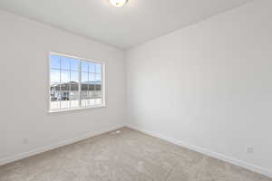 Carpeted empty room featuring baseboards