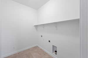 Laundry room featuring washer hookup, electric dryer hookup, and light tile patterned flooring