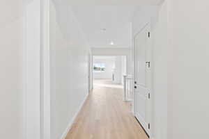 Hall with light wood-style floors and baseboards