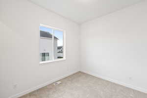 Spare room featuring baseboards and carpet
