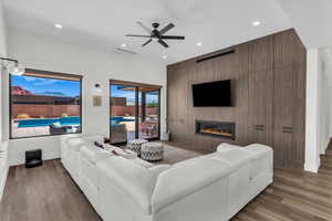 Living area with recessed lighting, a fireplace, an accent wall, dark wood-type flooring, and a ceiling fan
