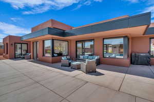 Rear view of property with outdoor lounge area, stucco siding, and a patio area