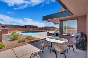 Fenced backyard with a patio, outdoor dining area, and grilling area