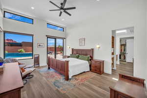 Bedroom with a high ceiling, light wood-type flooring, access to exterior, recessed lighting, and ceiling fan