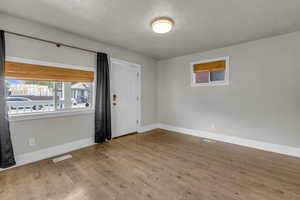 Foyer entrance with wood finished floors and a textured ceiling