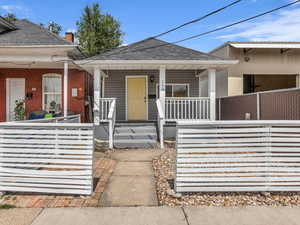 View of front of home with a porch and roof with shingles