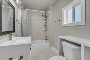 Bathroom with shower / bath combo, light tile patterned flooring, and vanity