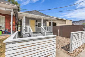 View of front facade featuring roof with shingles, a mountain view, and a porch