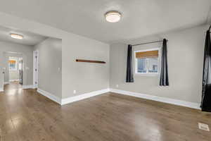 Unfurnished room featuring wood finished floors and a textured ceiling