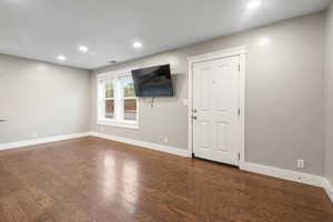 Unfurnished living room with dark wood-style floors and recessed lighting