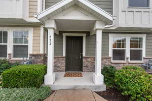 Entrance to property with stone siding and covered porch