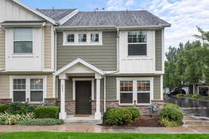 View of front of property featuring board and batten siding, stone siding, and a shingled roof