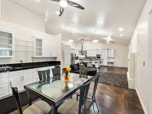 Dining area with ceiling fan, concrete floors, lofted ceiling, and a textured ceiling