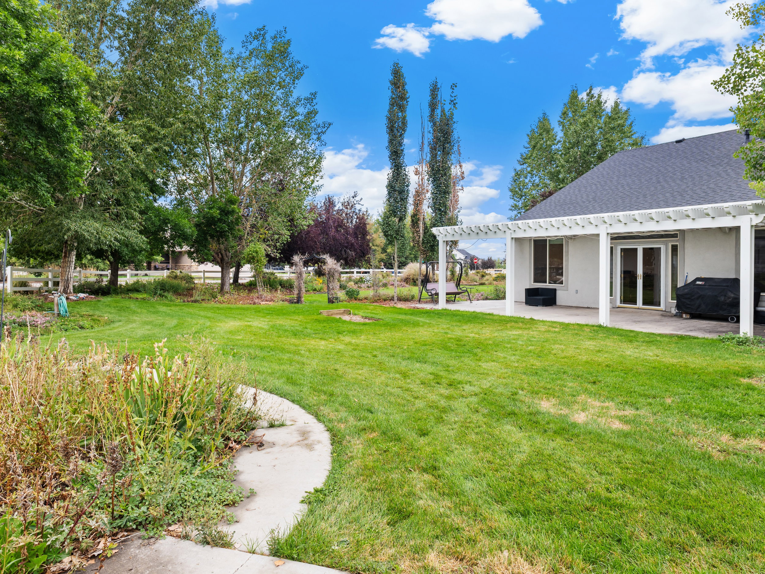 View of grassy yard with a patio area and a pergola