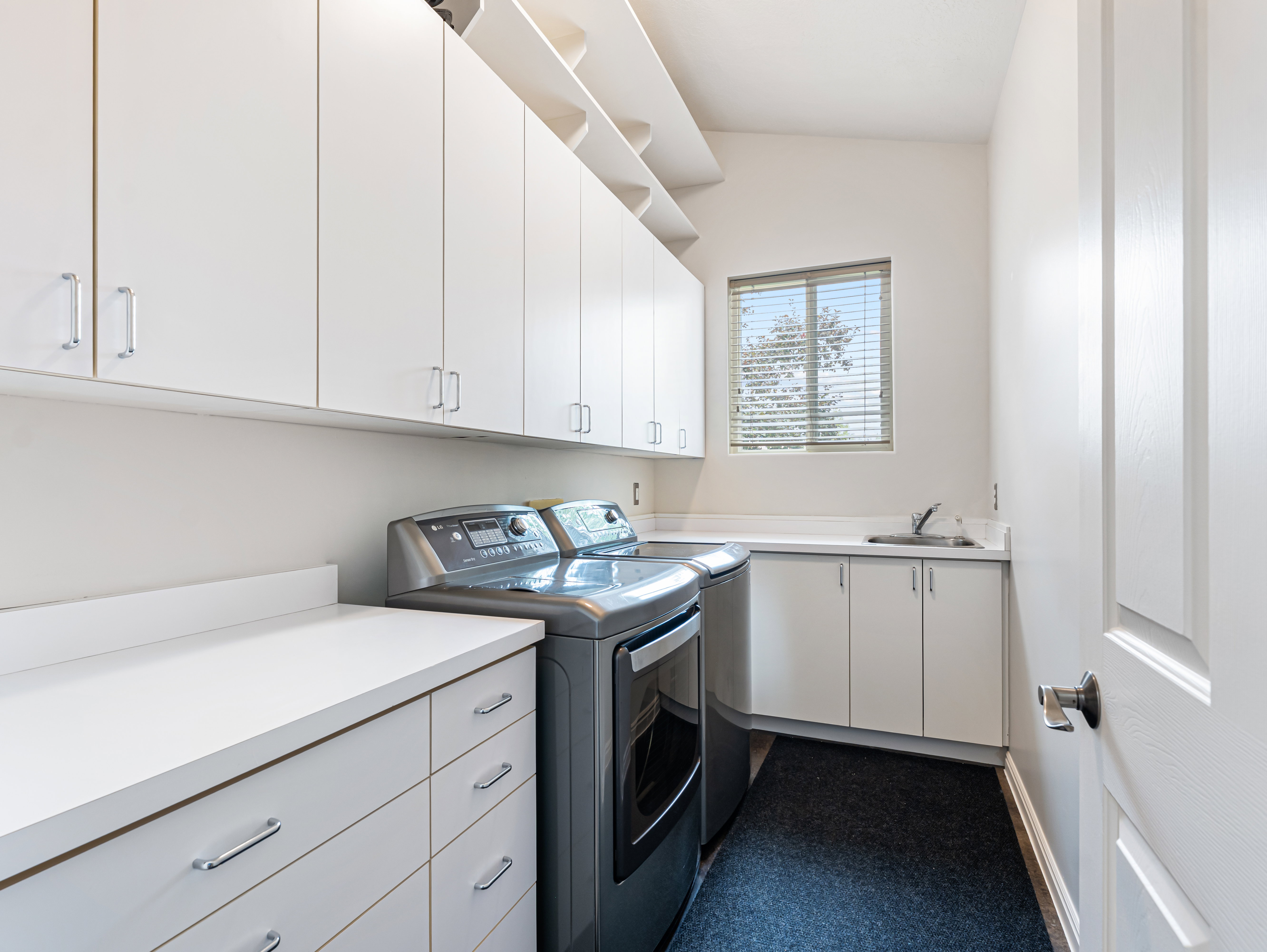 Fantastic Laundry room featuring a sink,  ample cabinet space and  washer and dryer included!