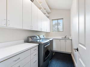 Fantastic Laundry room featuring a sink,  ample cabinet space and  washer and dryer included!