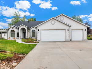Single story home with stucco siding, concrete driveway, an attached garage, a front yard, and a shingled roof