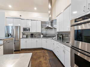 Kitchen featuring stainless steel counters, appliances with stainless steel finishes, plenty of cabinet storage, backsplash, Gas Cook top and exhaust hood, Extra Prep sink next to double Ovens
