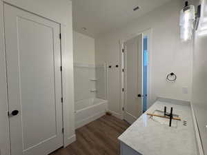 Full bath featuring vanity, dark wood-style floors, and bathing tub / shower combination
