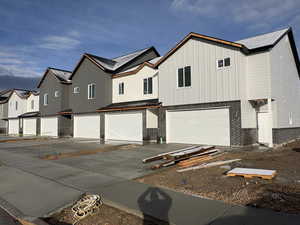 View of front of house featuring brick siding, a residential view, a garage, and concrete driveway