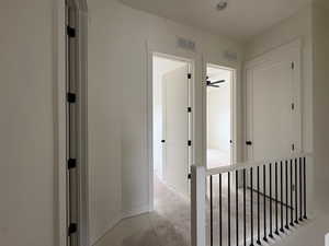 Corridor featuring concrete flooring and baseboards