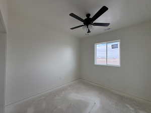 Empty room featuring unfinished concrete floors and a ceiling fan