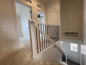Staircase featuring baseboards and ceiling fan