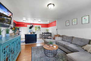 Living room featuring light wood-style flooring and a wainscoted wall