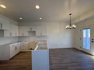 Kitchen featuring white cabinets, recessed lighting, dark wood finished floors, and hanging light fixtures