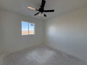 Spare room with a ceiling fan and baseboards