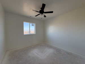 Unfurnished room with a ceiling fan, a textured ceiling, and unfinished concrete flooring