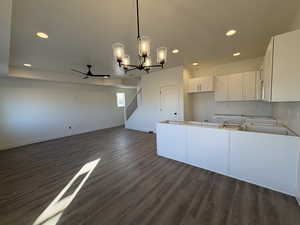 Kitchen featuring a chandelier, white cabinets, pendant lighting, recessed lighting, and open floor plan