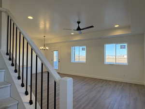 Foyer with wood finished floors, ceiling fan, a chandelier, healthy amount of natural light, and recessed lighting